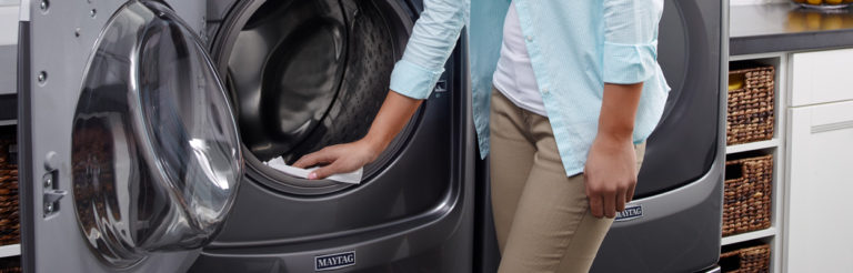 Person wiping front loading washing machine