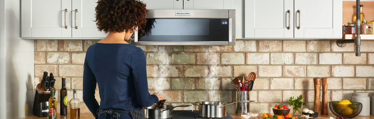 woman with 2 pots on a gas range